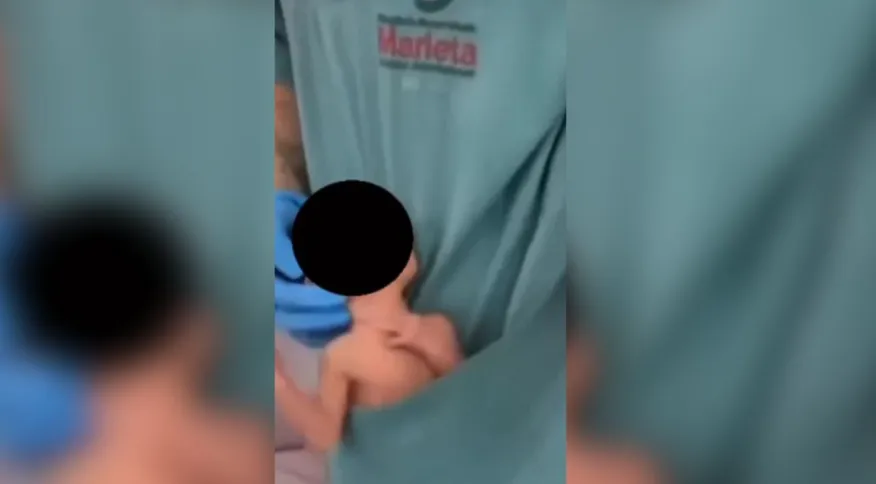 Imagem mostra recém-nascido no bolso de jaleco Reprodução
